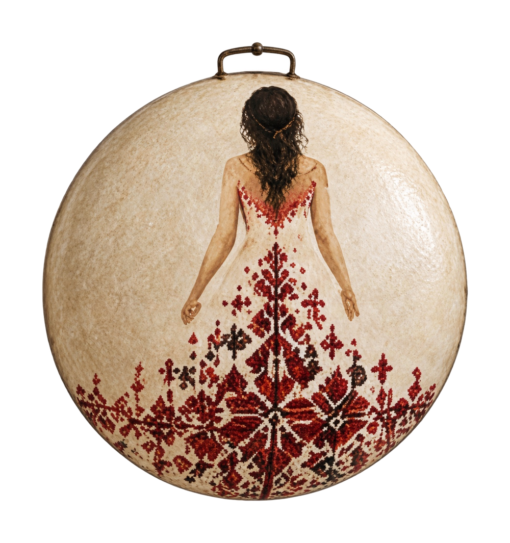 A woman seen from behind wears an ivory sleeveless dress whose red and dark floral embroidery spreads across the lower half of a saj.